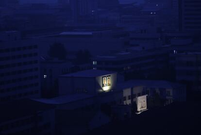 Retratos de los últimos líderes norcoreanos Kim Il Sung y Kim Jong Il iluminados en un edificio al amanecer en Pyongyang, Corea del Norte.