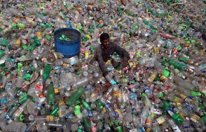 Un hombre selecciona botellas en un basurero en Chandigarh.