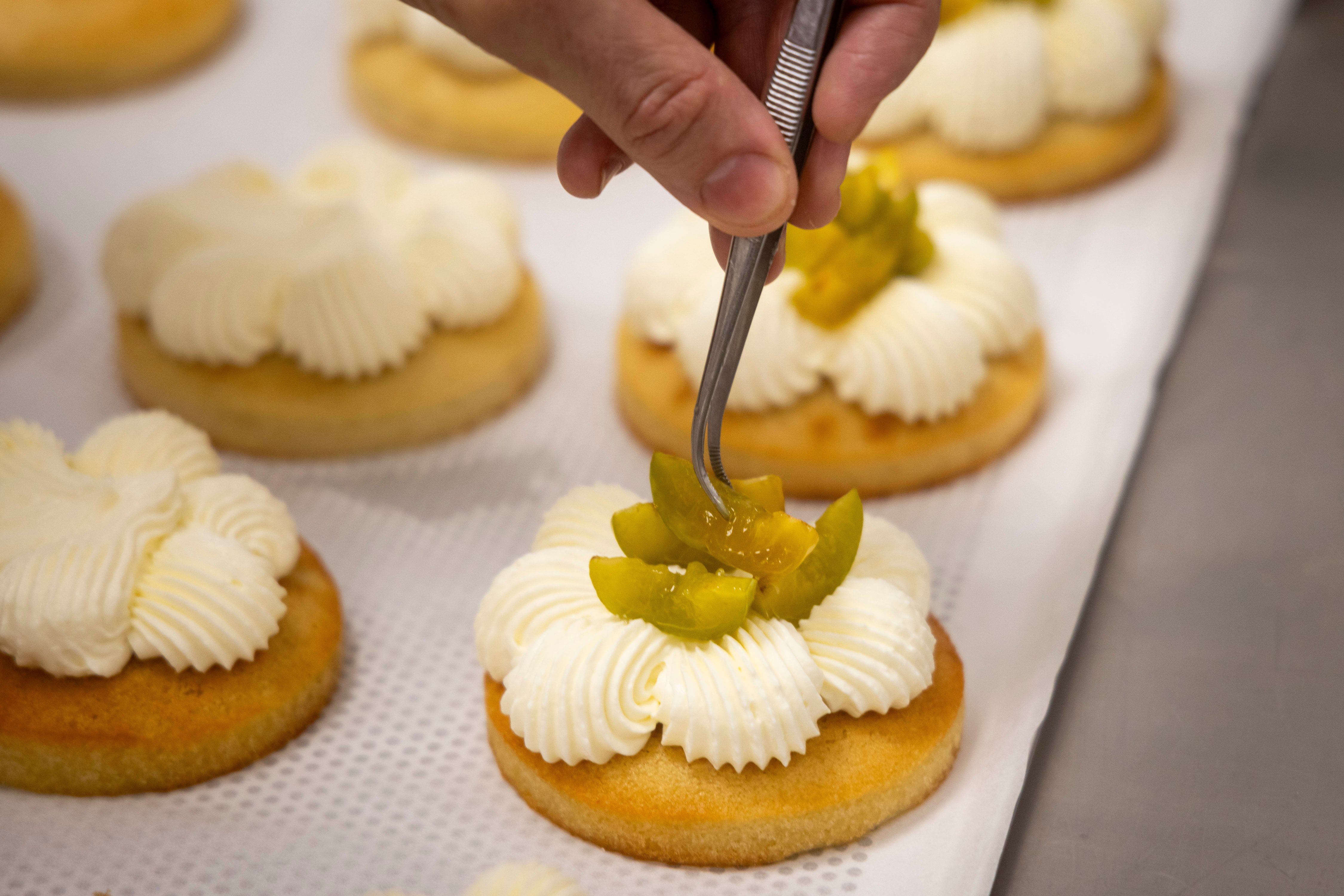 Base de bizcocho financier con crema de queso y ciruela claudia confitada, de Camín Postrería.