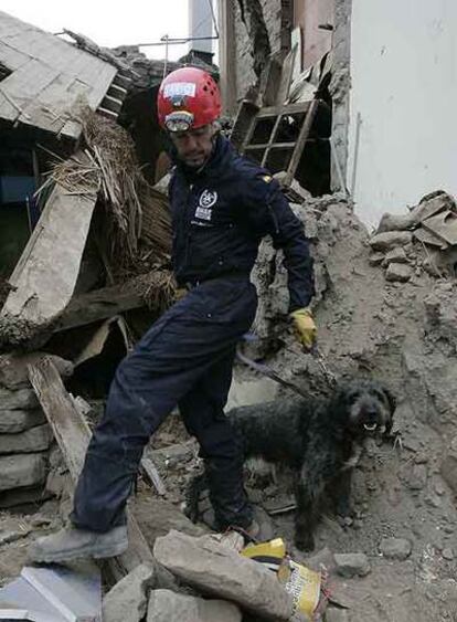 Un bombero español, con su perro de rescate ayer en Pisco.