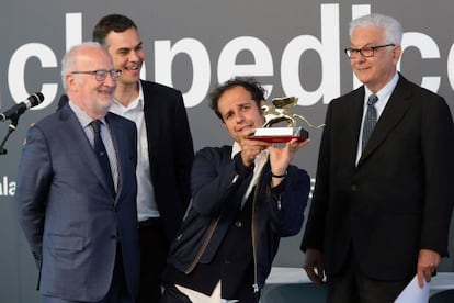 El artista Tino Sehgal recoge el Le&oacute;n de Oro entre los miembros del jurado.