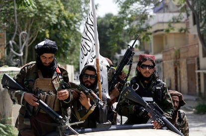 Los combatientes talibanes despliegan su bandera mientras patrullan Kabul, capital de Afganistán