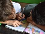 Dos niños leen un libro. 