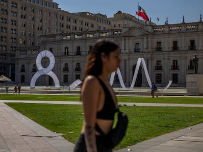 Una mujer camina frente al palacio presidencial de La Moneda, en Chile, el 8 de marzo de 2023.