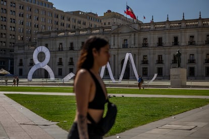 Una mujer camina frente al palacio presidencial de La Moneda, en Chile, el 8 de marzo de 2023.