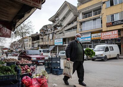 Un hombre compra delante de un edificio derrumado, este miércoles en kahramanmaras, Turquía.