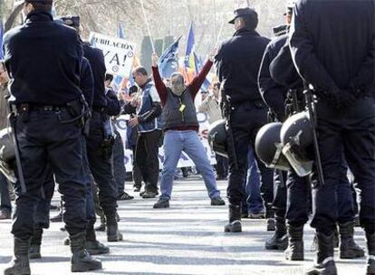 Un manifestante, vestido de Gallardón y rodeado de agentes con sus uniformes.