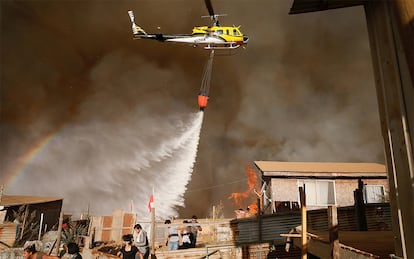 Un helicóptero lanza agua a las llamas durante el incendio forestal en Viña del Mar (Chile), el 12 de marzo de 2017.