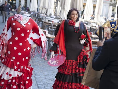 Una turista se fotografía con un traje de flamenca, en la Plaza de Mayor de Madrid. 