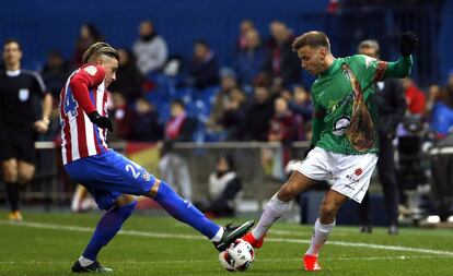 Giménez, central del Atlético, pelea la pelota con Carmona, futbolista del Guijuelo.