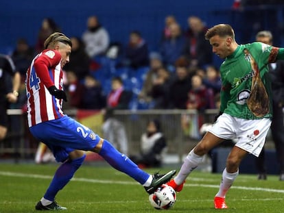 Gim&eacute;nez, central del Atl&eacute;tico, pelea la pelota con Carmona, futbolista del Guijuelo.