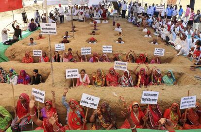 Granjeros indios permanecen enterrados durante una protesta en contra de la ley de adquisición de tierras promovida por el Gobierno indio, en la localidad de Nindar, India.