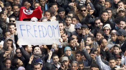 Los manifestantes se agolpan junto a una pancarta en la que piden libertad para los tunecinos durante las protestas que forzaron ayer la salida del presidente Ben Ali.