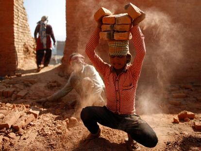 Un trabajador apila ladrillos en su cabeza en una fábrica de ladrilos de Lalitpur, Nepal.