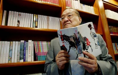 El novelista Jin Yong, con uno de sus libros en Hong Kong, en 2002.