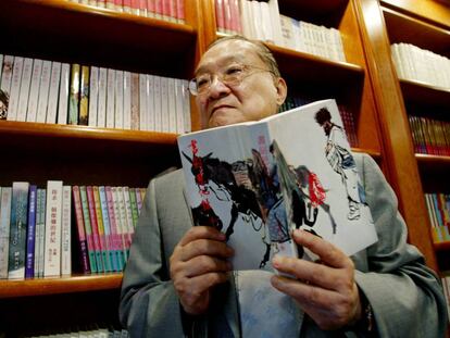 El novelista Jin Yong, con uno de sus libros en Hong Kong, en 2002.