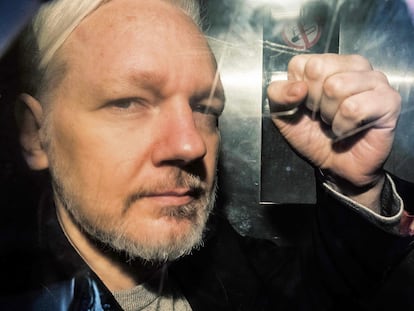 Julian Assange, saluda a los fotógrafos desde el interior de una furgoneta a la salida de un tribunal, en Londres en mayo de 2019.