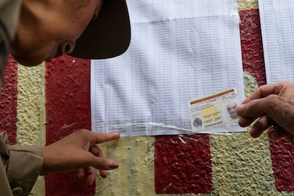 Un grupo de ciudadanos busca su nombre en las listas de votantes. 