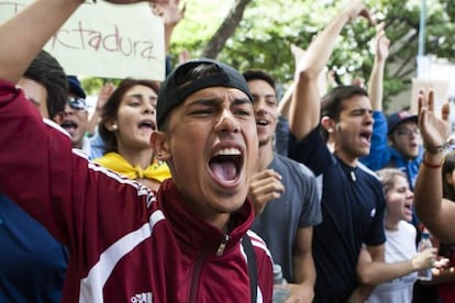 J&oacute;venes venezolanos gritan consignas frente a la Comisi&oacute;n Nacional de Telecomunicaciones.
