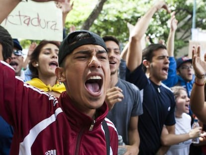 J&oacute;venes venezolanos gritan consignas frente a la Comisi&oacute;n Nacional de Telecomunicaciones.