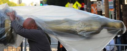 Un operario transporta un elemento de decoración en las inmediaciones del Teatro Kodak de Los Ángeles, donde el domingo se celebrará la ceremonia de los Oscar.