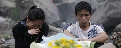Una pareja recuerda a su hijo fallecido por causa de la catástrofe natural ocurrida hace exactamente un año en la localidad china de Wenchuan