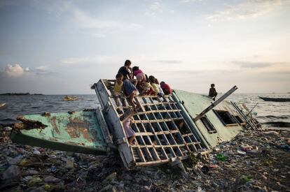 Niños juegan en una embarcación de madera en Manila (Filipinas).