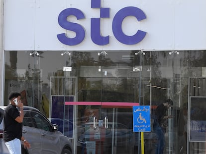 Un hombre habla por teléfono junto a la sede de STC en Riad.