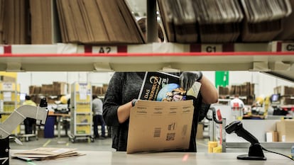 Una empleada de Amazon introduce un libro para su envío en los almacenes de la compañía en Brieselang, Alemania.