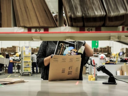 Una empleada de Amazon introduce un libro para su envío en los almacenes de la compañía en Brieselang, Alemania.