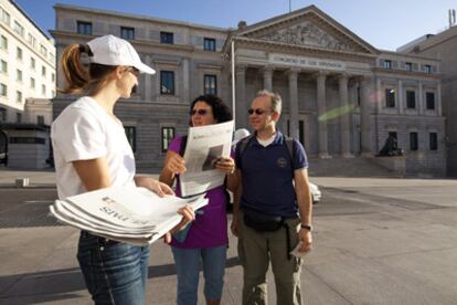 La artista francesa Elvire Bonduelle reparte ejemplares de su obra frente al Congreso.