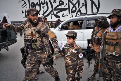 Un talibán lleva a su hijo, también vestido de militar, a las celebraciones en Kabul. 