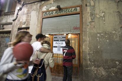 Puerta de entrada al bar Marsella, con la persiana a medio subir, anoche.