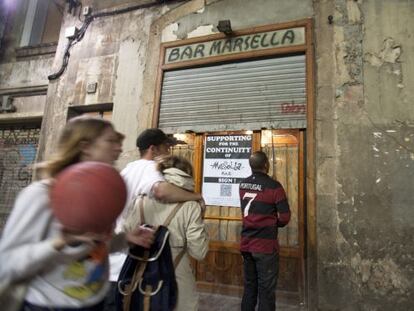 Puerta de entrada al bar Marsella, con la persiana a medio subir, anoche.