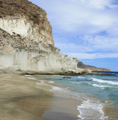 A medio camino entre Agua Amarga y la cala del Plomo, conserva la virginidad de siempre en el parque natural del Cabo de Gata-Níjar. En ella asombran, en su flanco izquierdo, erosiones eólicas y marinas labradas en la piedra arenisca. A mano derecha queda una suerte de oquedad donde reverbera el oleaje. Las planchas rocosas desde las que zambullirse en un mar nítido y los colores cenicientos de la arena fina dan a este enclave un aire de magia y misterio. <p><b>Acceso:</b> 300 metros antes de la cala del Plomo está el arranque de la senda de 1,7 kilómetros (unos 25 minutos) a la cala de Enmedio. Más incómodo resulta hacerlo desde Agua Amarga (45 minutos).</p>