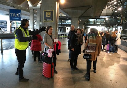 Una persona indica als viatgers com poden desplaçar-se des de l'aeroport de Barajas fins a Madrid.