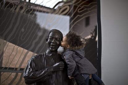 Una niña sudafricana besa la estatua del presidente Nelson Mandela en Johannesburgo (Sudáfrica).