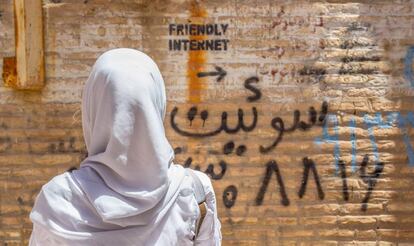 Una mujer observa una pintada que indica un lugar con internet sin censura en Irán.