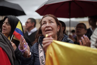 Una mujer sostiene un rosario durante el funeral del senador fallecido, en Bogotá.