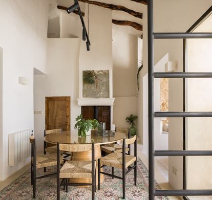 El comedor a doble altura se sitúa en el centro del proyecto y está compuesto por una gran mesa circular de madera maciza sobre suelo hidráulico recuperado y presidida por una chimenea con un fresco original que apareció durante la reforma, oculto tras capas de yeso.