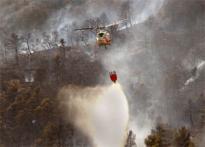 Un helicóptero descarga agua en la zona más alta del incendio de Sorita, ayer.