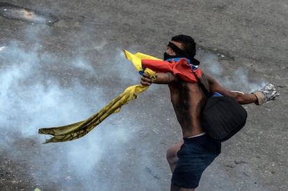 Un manifestante opositor lanza un bote de gas contra la policía durante una protesta en Caracas, el 24 de junio de 2017.