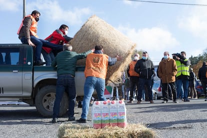 Varios ganaderos descargan una paca de paja durante una protesta en Lugo para reclamar precios "justos" en el mercado lácteo.