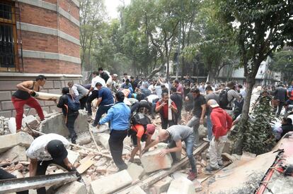 Pessoas buscam feridos debaixo de escombros de um prédio na capital do México que derrubado pelo terremoto que atingiu o país.