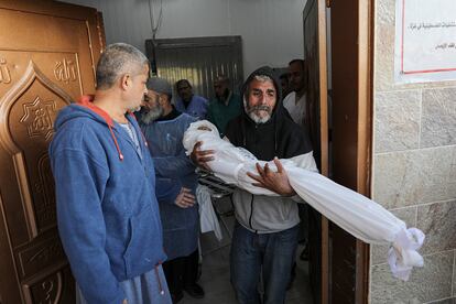 El cuerpo envuelto de un niño de nueve años es llevado por su abuelo al hospital Nasser tras los ataques aéreos israelíes en Khan Yunis, al sur de la franja de Gaza, este martes 21 de noviembre.