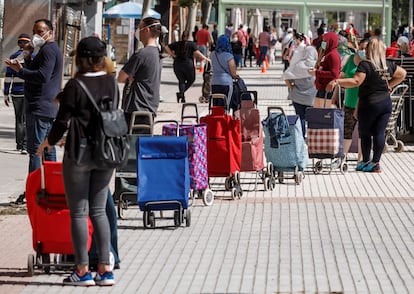 Cola para recibir comida ante una asociación vecinal de Madrid, el 23 de mayo de 2020.