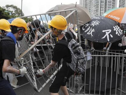 Manifestantes colocan vallas de metal para bloquear una vía en el distrito de Sha Tin, en Hong Kong. 