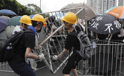 Manifestantes colocan vallas de metal para bloquear una vía en el distrito de Sha Tin, en Hong Kong.