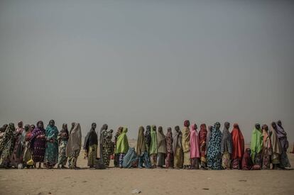 Mujeres refugiadas hacen cola en un campo de refugiados para acceder a un kit de higiene.