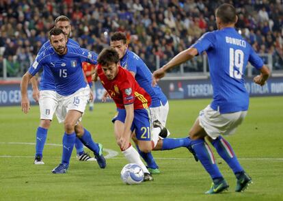 David Silva intenta escaparse de los defensas de Italia.
